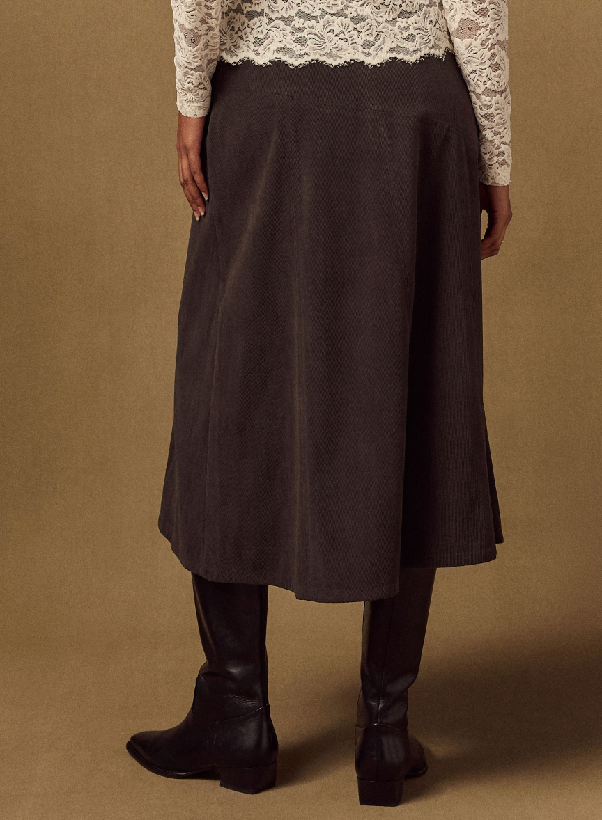 person wearing a long dark skirt with lace top and black boots, seen from behind. person wearing a long dark skirt with lace top and black boots, seen from behind.