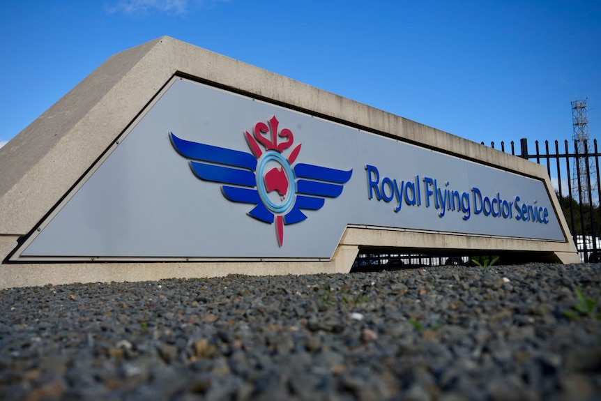 A sign for the Royal Flying Doctor Service which includes a red and blue logo with wings