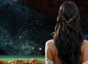 Rear view of a lone woman gazing at the stars - in the foreground is a green ocean and orange crystals
