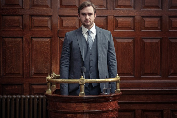 emmerdale-tom-court-dock Tom King dressed in suit and tie as he stands trial in Emmerdale