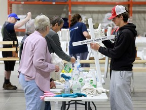 Volunteers cleaning and repairing crosses for the Field of Crosses
