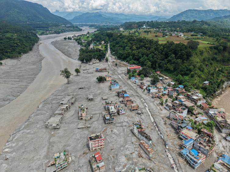Mud covers a river-side village. The flood spread far from the river's banks, fully engulfing some homes.