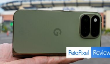 A hand holds a green smartphone with a dual-lens camera module on the back, with a PetaPixel Reviews logo in the corner.