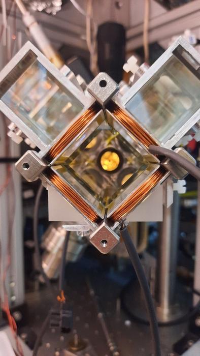 A metal structure with orange coils on it and a yellow circle at its center.