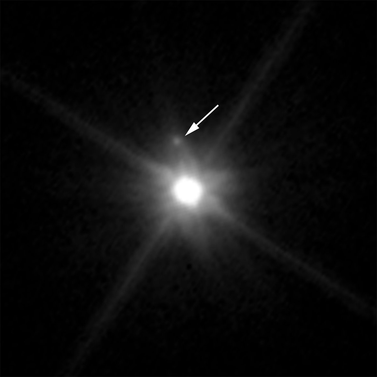 Hubble Space Telescope image showing the first moon (indicated by the arrow) ever discovered around the dwarf planet Makemake (the bright object in the centre). Credit: NASA, ESA, and A. Parker and M. Buie (Southwest Research Institute)