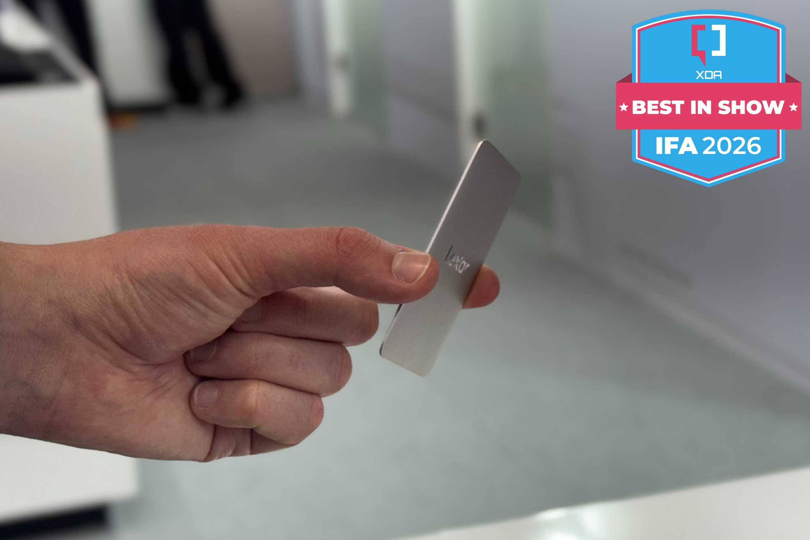 A Lexar Muse SSD held between a person's fingers with a badge reading XDA Best in Show IFA 2026