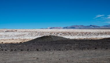 Dark volcanic terrain beside bright salt flats in Chile's Atacama Desert