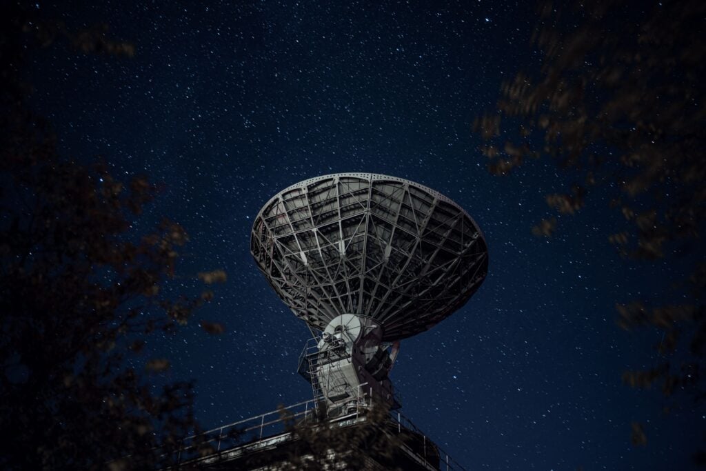 Astronomers used 69 fast radio bursts as cosmic backlights to complete the clearest census yet of the universe’s missing ordinary matter, finding that roughly 76% resides as extremely diffuse ionized gas in the vast spaces between galaxies — while only 9% remains inside galaxies as stars and gas.
