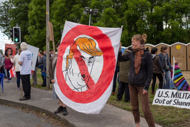 Shannon, Ireland, June. 5, 2019: Young women with a banner protesting against the Donald Trump visit at Shannon Airport, Ireland