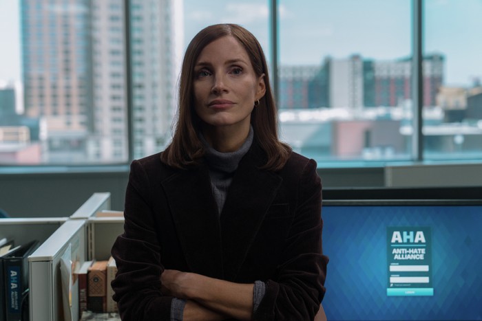 savant-jessica-chastain-jodi Jessica Chastain as Jodi Goodwin in The Savant, stood in a room with a computer behind her, wearing a grey sweater and a dark blazer.