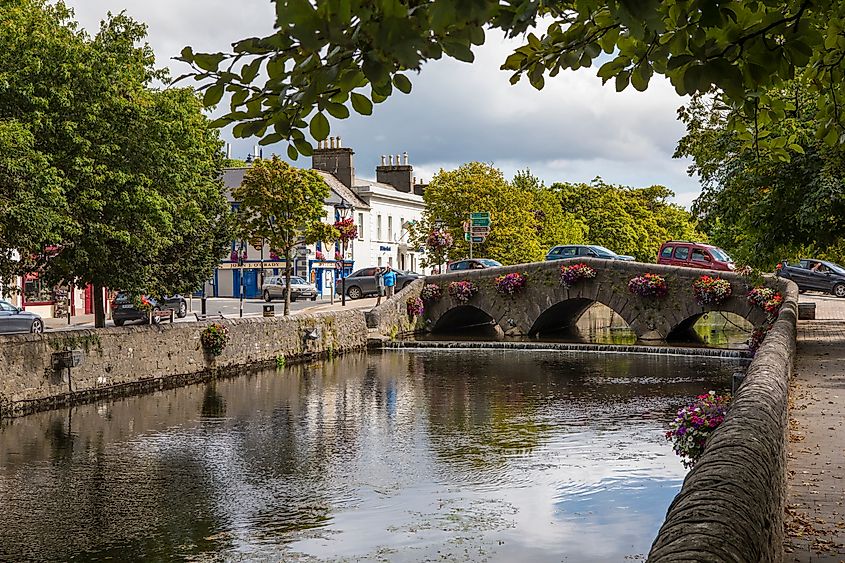 A stone bridge crossing the Carrowbeg River between the tree-lined promenades of The Mall in Westport, County Mayo.