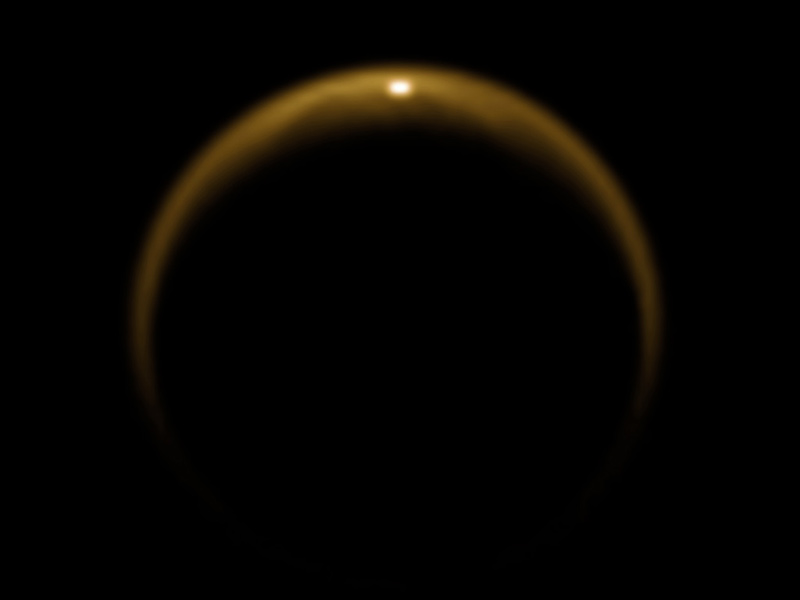 An image of Titan captured by the Cassini spacecraft on  July 2009. The bright spot at the top of Titan’s disc is sunlight reflecting off the surface of a hydrocarbon lake. Credit: NASA/JPL/University of Arizona/DLR