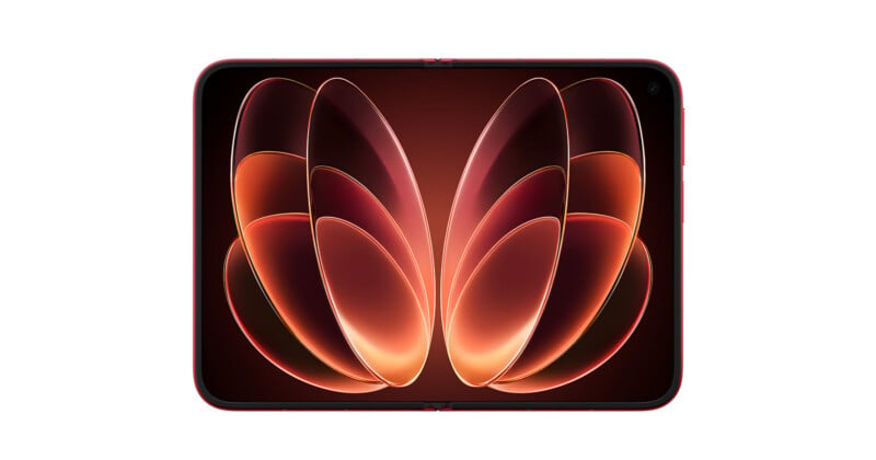 A red foldable smartphone is shown in an open, flat position against a white background, displaying an abstract orange and red petal-like wallpaper.