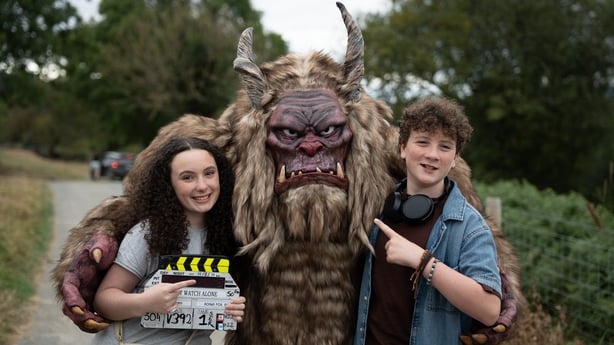 A young boy and girl actor pose with a monster from from the show Do Not Watch Alone