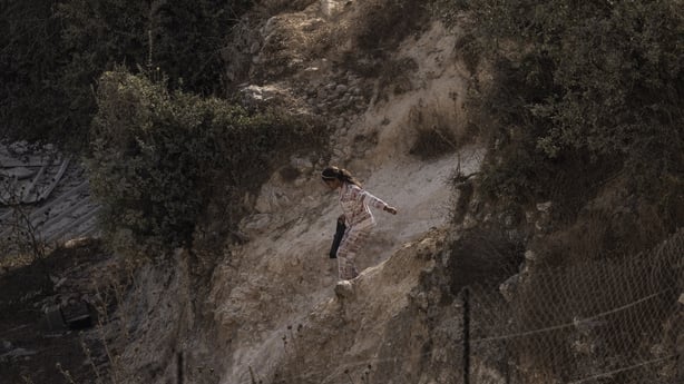 A young Palestinian girl makes her way down a hill after Israeli forces blocked roads leading to her house