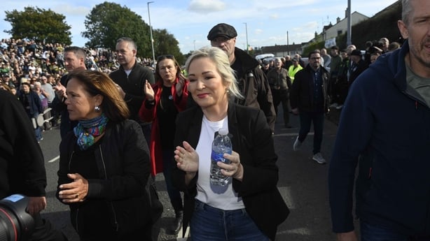 mary lou mcdonald and michelle o'neill are seen amongst crowds of people 