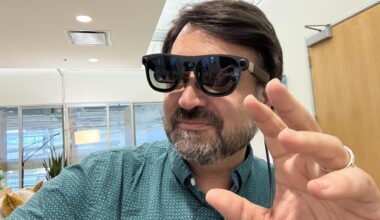 A man wearing Project Aura glasses and gesturing with his left hand.