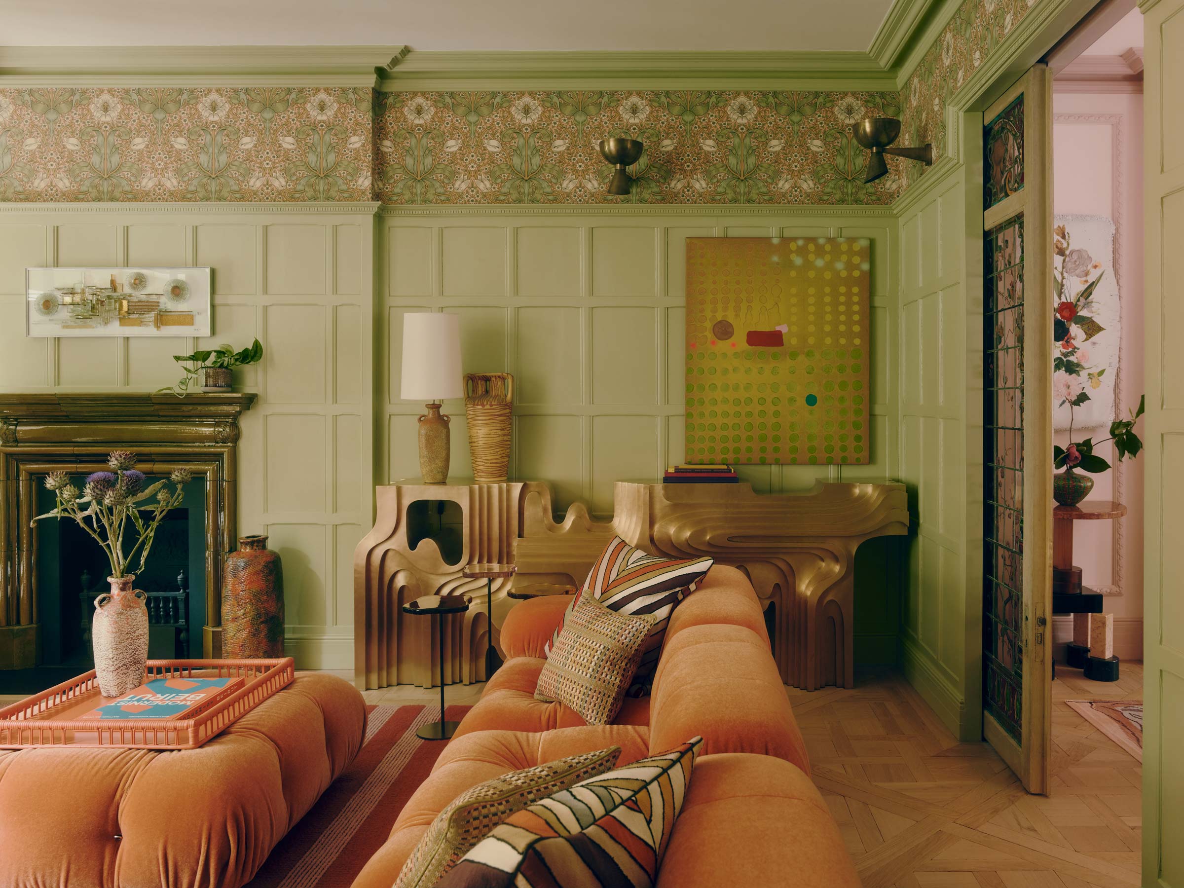 A contemporary living room with antique panelling and hyper-contemporary sculptural furnishings