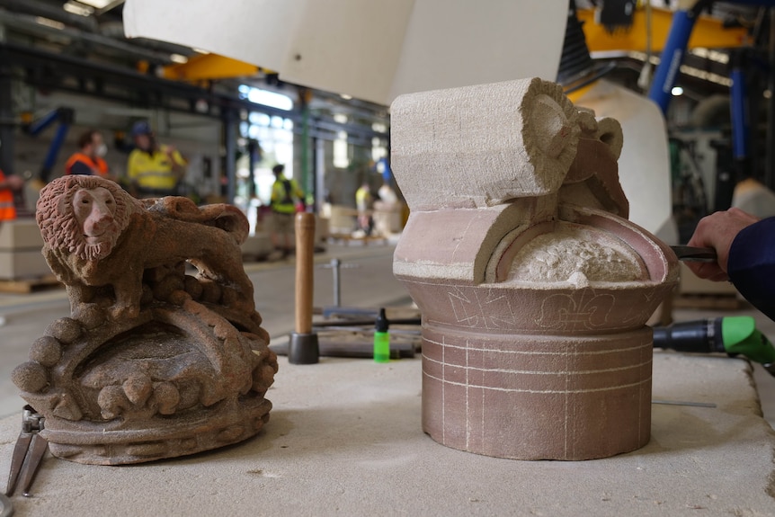 a sandstone model of a lion atop a crown on a benchtop