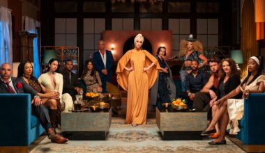 parker posey poses in front of the reality tv contestants appearing on hulu's the mob as they sit in chairs and stand around her in a promotional shot