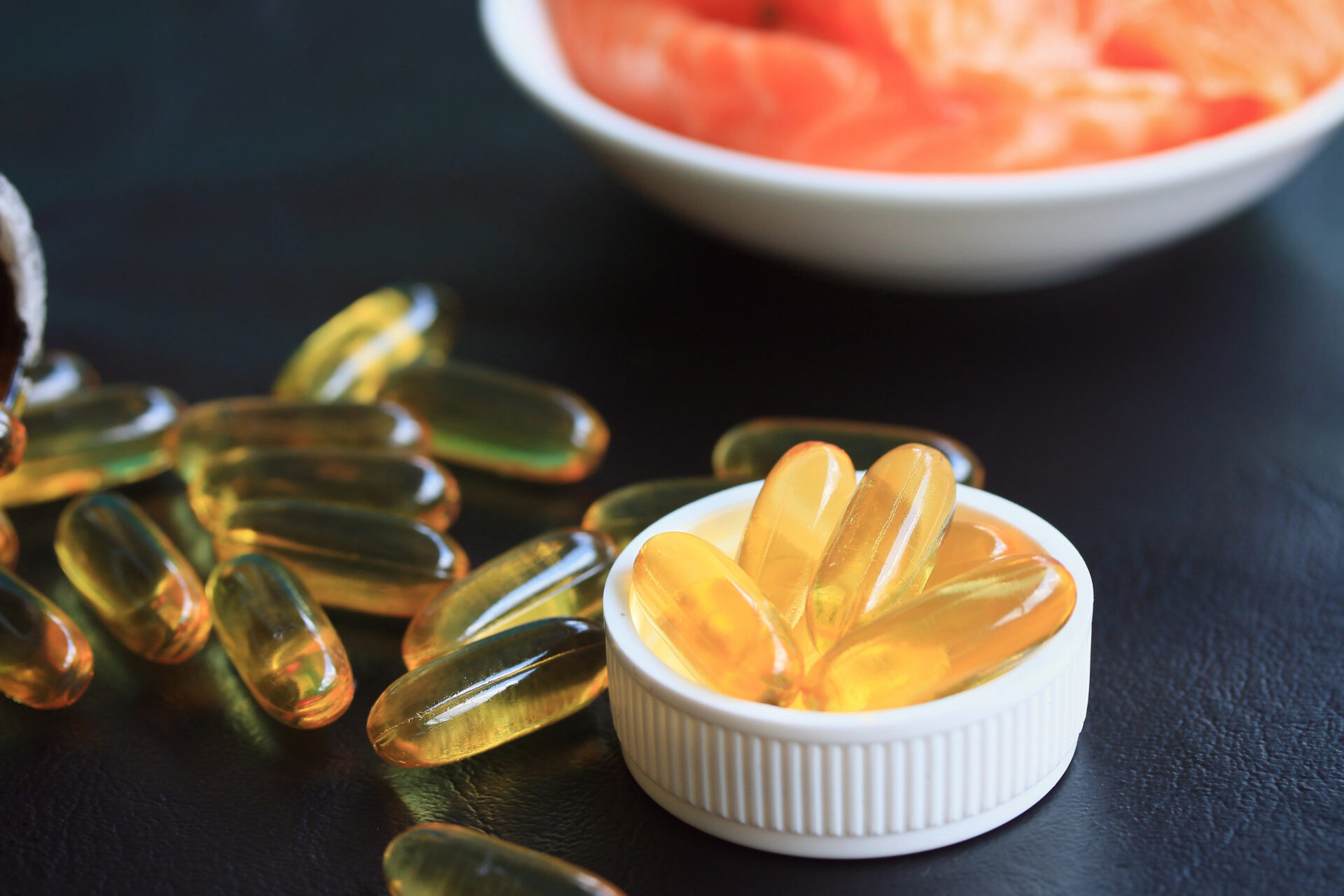 Omega-3s & DHA on a black background surrounded by salmon