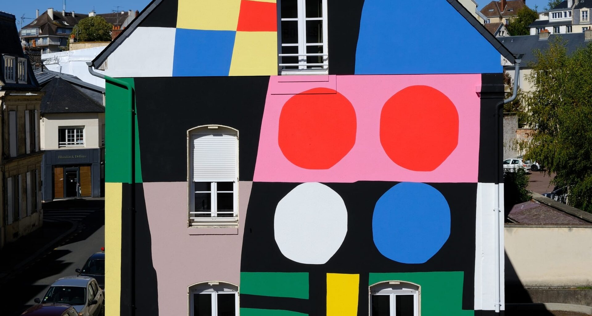 a colorful, geometric abstract mural on an urban wall