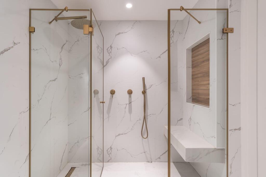 שדרוג חדר רחצה בפרויקט מחיר למשתכן - חיפוי פולימרי פרימיום דיזיין משולב עם אריחים דמוי עץ בנישה. עיצוב: איציק גבריאל 