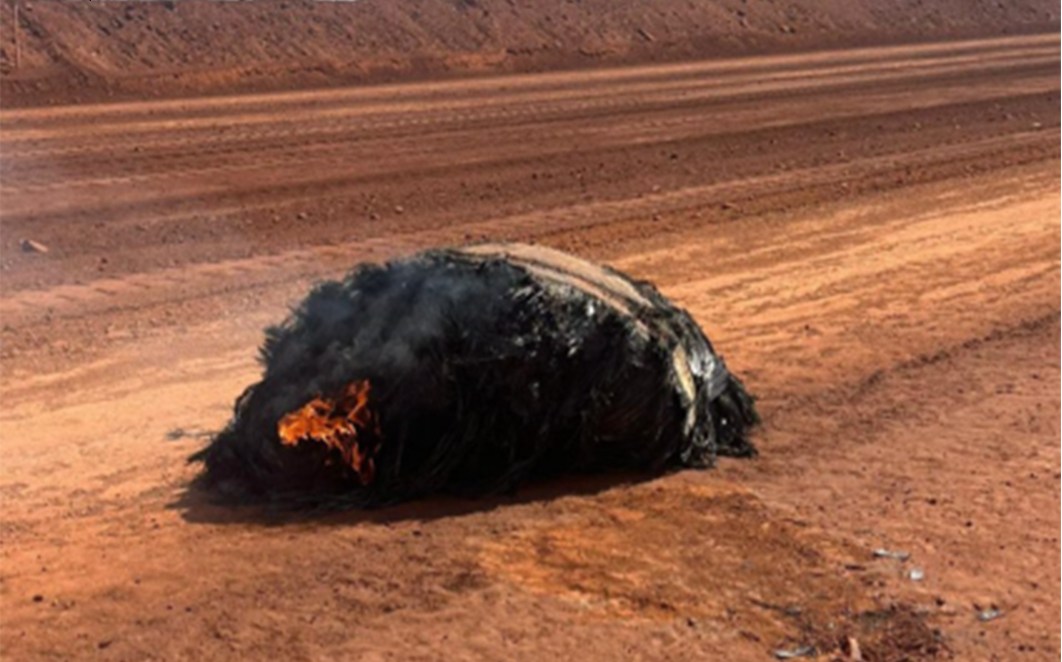Suspected space junk burning on a dirt road near an iron ore mine in the Australian desert.
