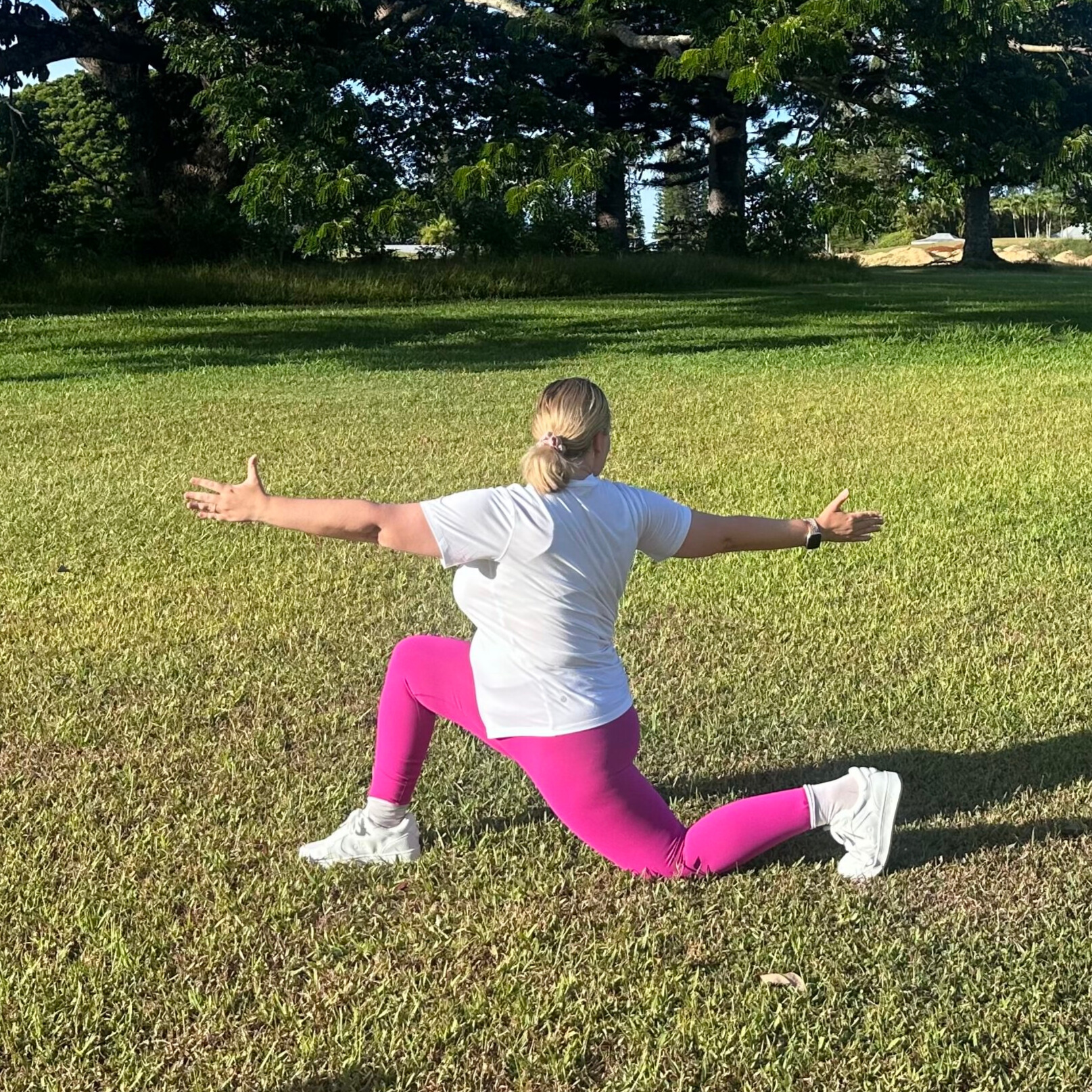 Woman demonstrating stretches on grass