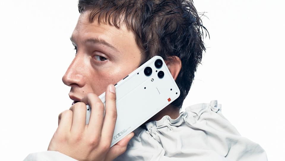 Marketing phone for the Nothing Phone 3a Lite. A suave-looking person holds the phone while on a call, looking nonchalantly over their shoulder toward the camera.