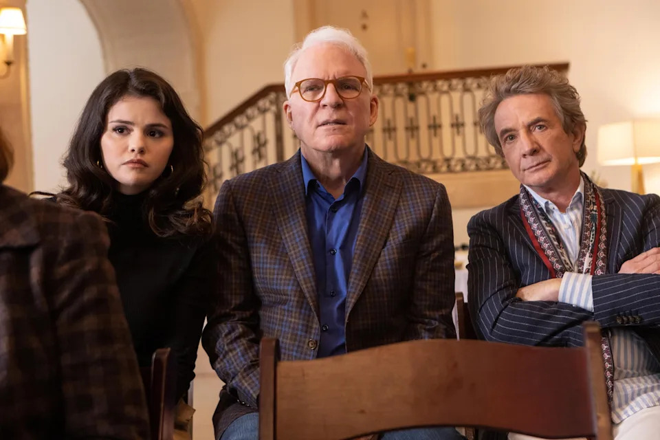 Selena Gomez, Steve Martin, and Martin Short seated looking concerned in a scene from "Only Murders in the Building."