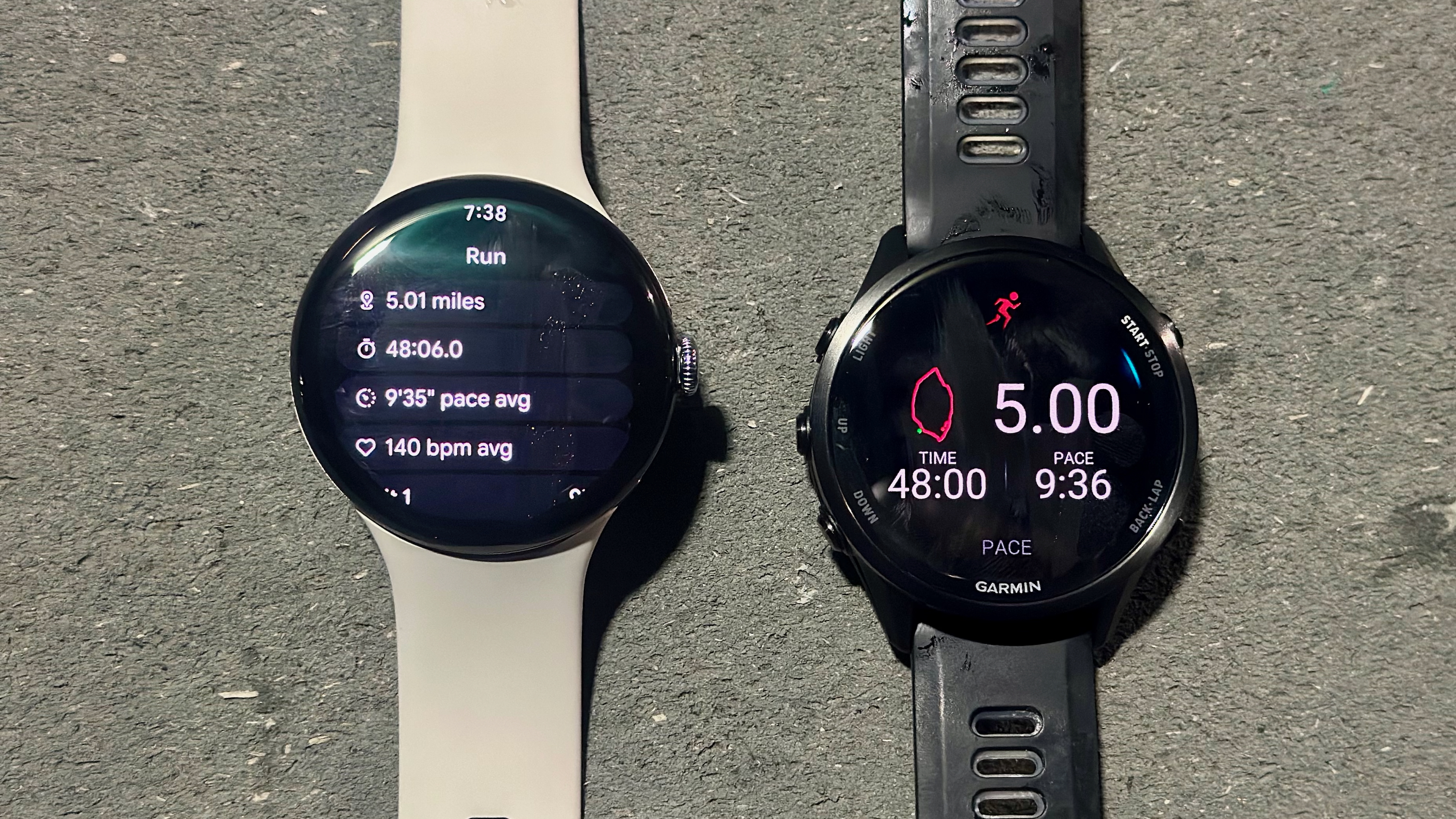 The Google Pixel Watch 4 (left, on a table) showing a post-run summary of distance, time, pace, and HR, while the Garmin Forerunner 970 (right) shows distance, time, and pace with a GPS map. The results between the two are similar.