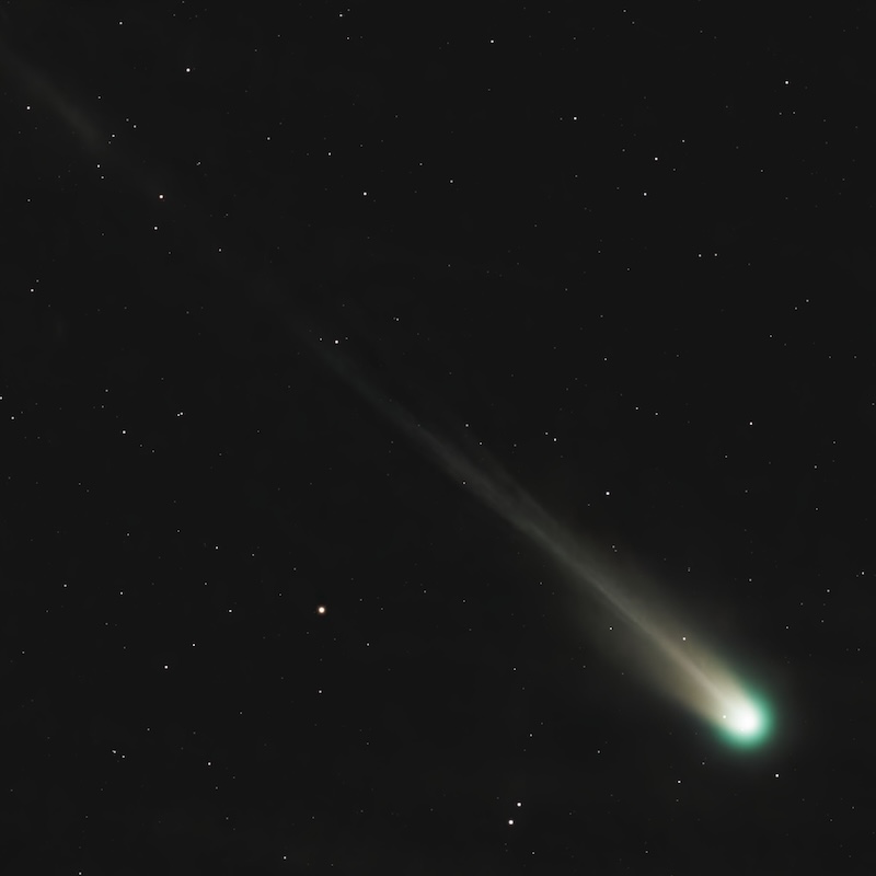 Round fuzzy greenish head of the comet and long, narrow tail with several strands.