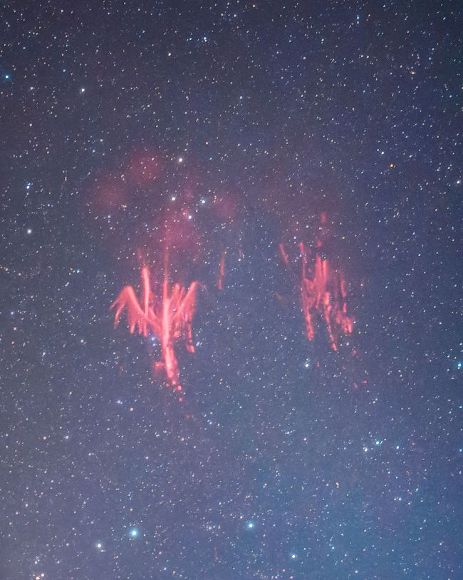 A starry background with streaks of bright red in two batches, one of which looks vaguely like a bird.