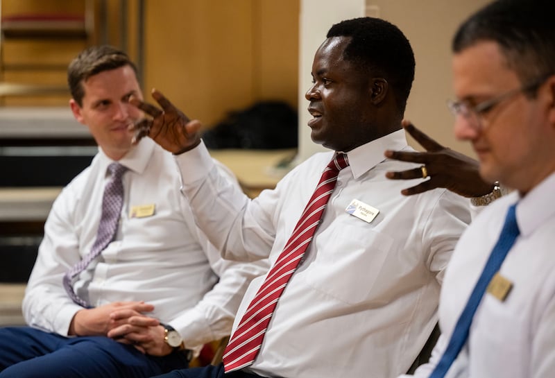 Pythagore Matubu, center, talks with global members of The Tabernacle Choir at Temple Square as they discuss their musical histories and how they feel about the opportunity to be members of the choir, during an interview in the Tabernacle in Salt Lake City on Tuesday, Sept. 23, 2025.