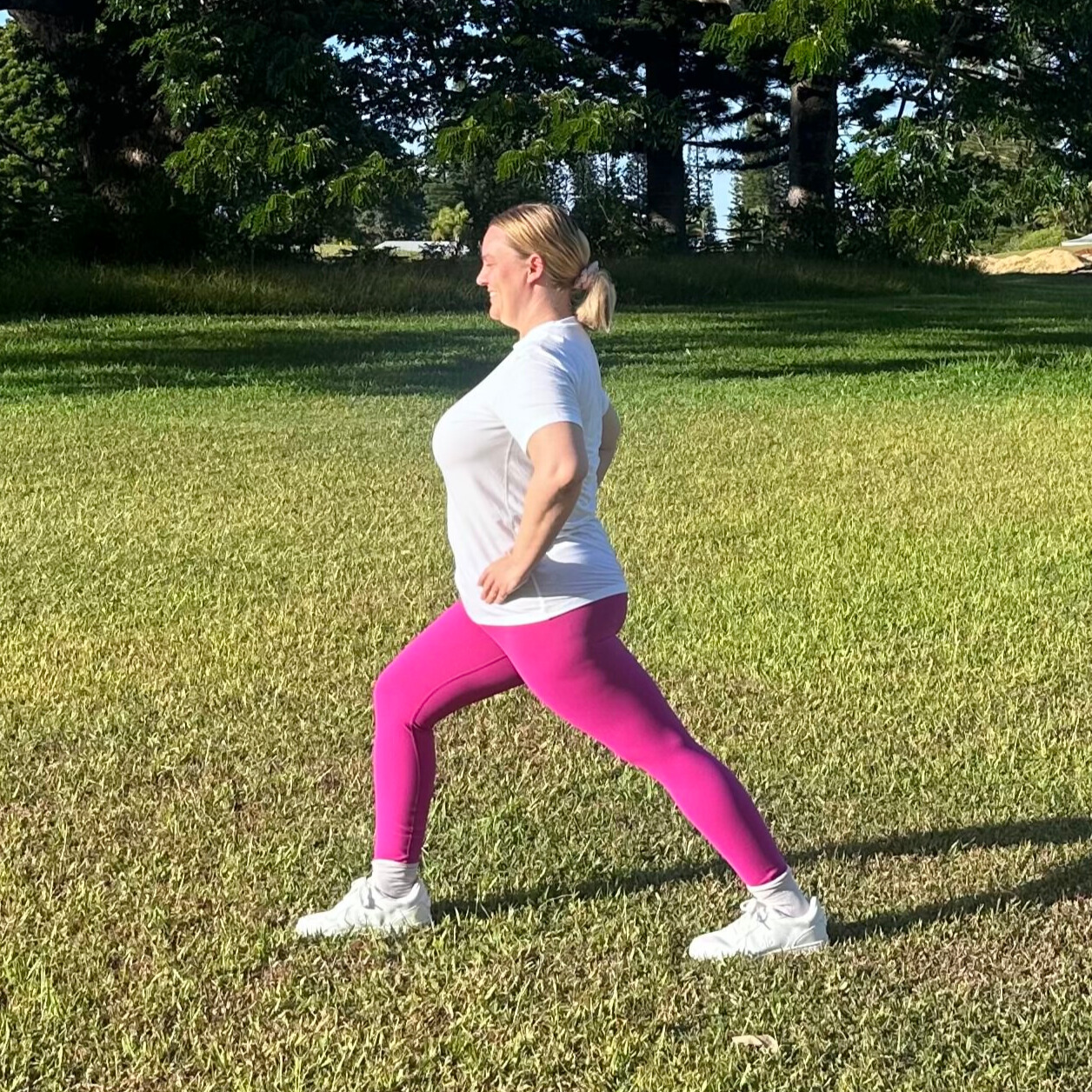 Woman demonstrating stretches on grass