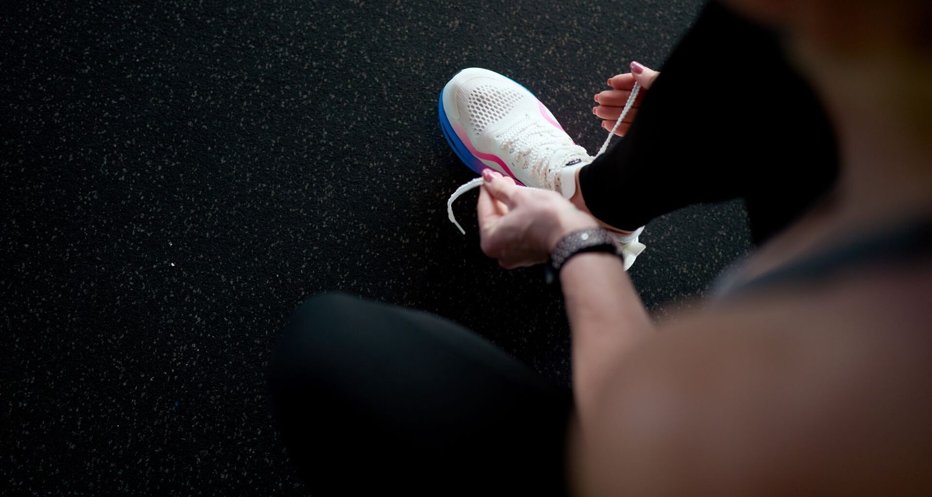 Woman tying shoelaces in gym