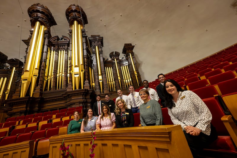 Global members of The Tabernacle Choir at Temple Square pose in front of the organ pipes in the Tabernacle as they discuss their musical histories and how they feel about the opportunity to be members of the choir, during an interview in the Tabernacle in Salt Lake City on Tuesday, Sept. 23, 2025.