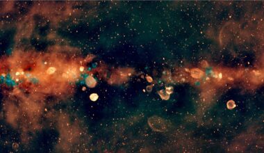 radio telescope view of the milky way's central band, showing it as an orange cloud studded with orange and blue spheres