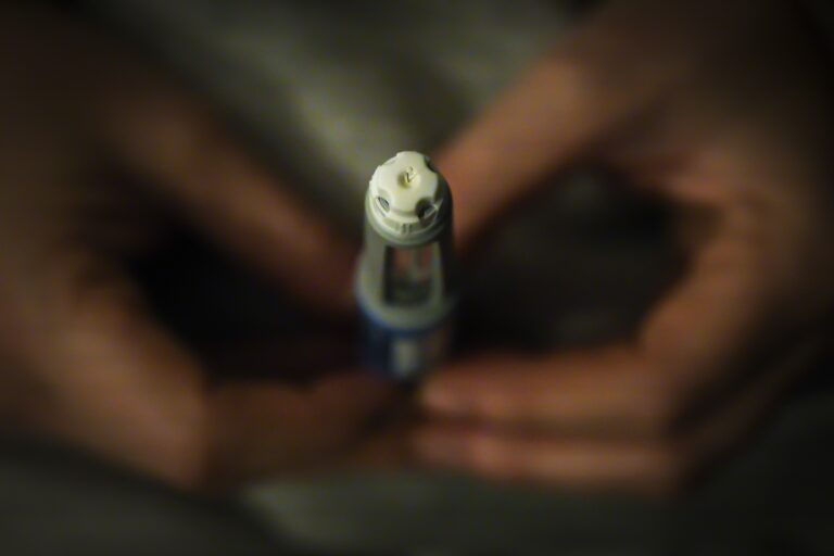 A close-up of an Ozempic injection pen held in a person's hands.