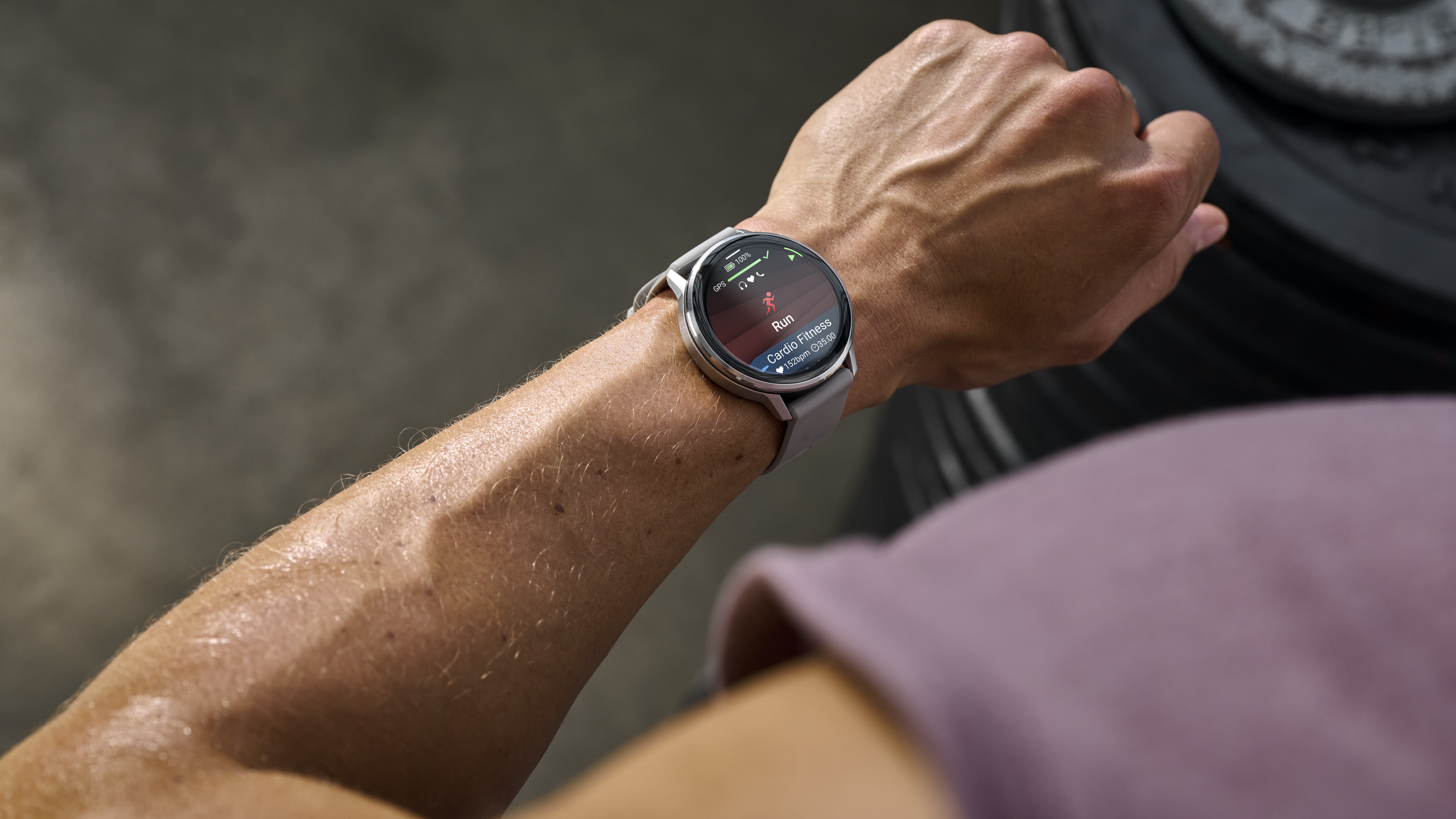 A photo of the Garmin Venu 4 on an athlete's wrist, showing a Run activity start screen.