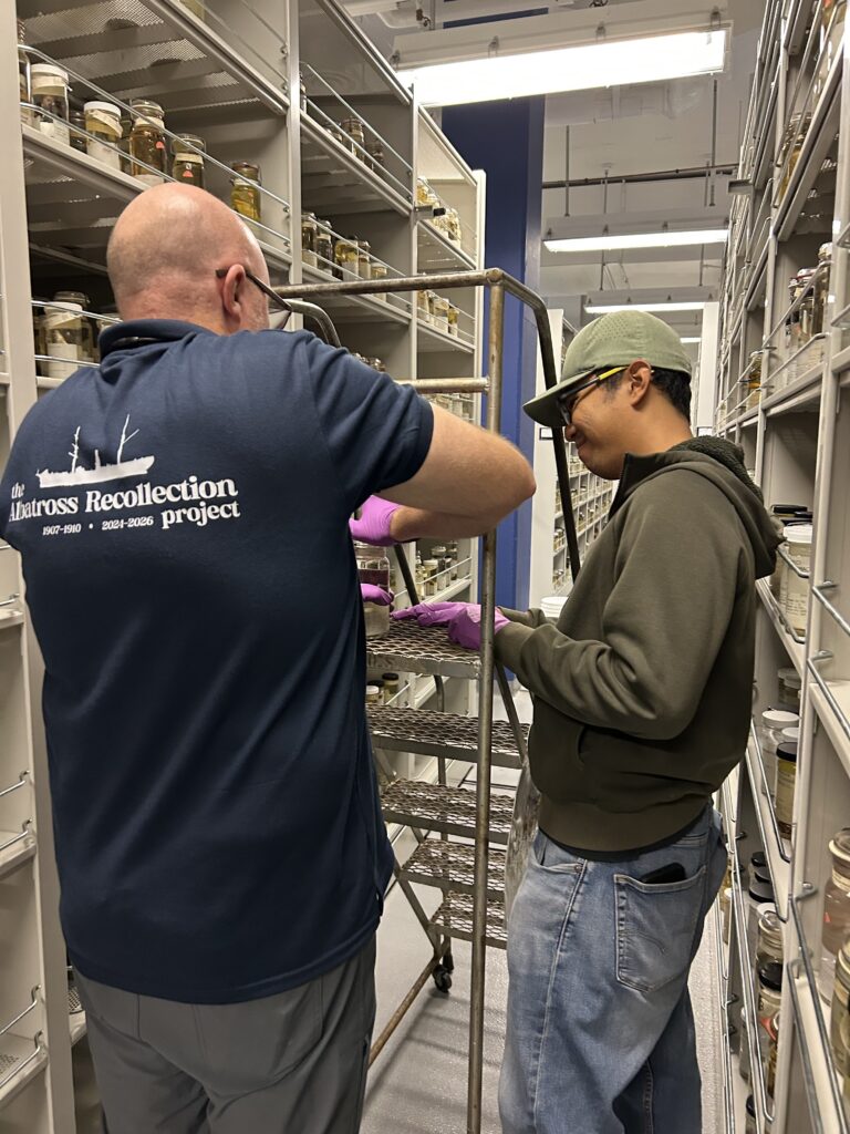 Researchers standing in the middle of specimen shelves full of jars