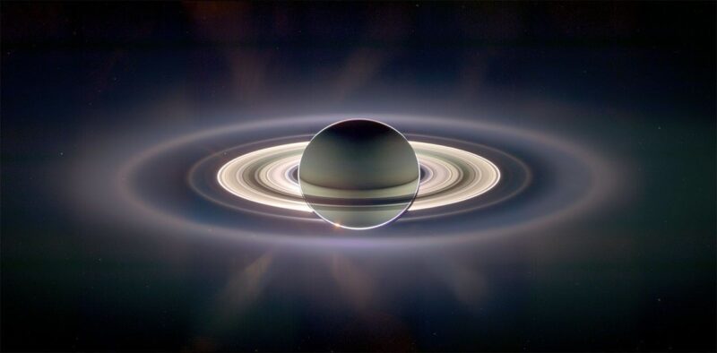The orb of Saturn and its extensive ring system with the planet showing through the rings and a glow behind it all.