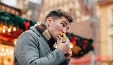 A man bites into a hotdog at a winter market