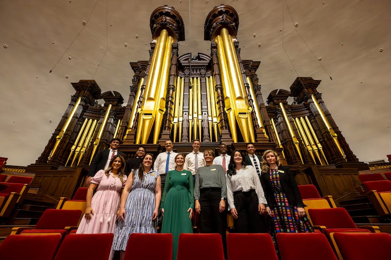 Global members of The Tabernacle Choir at Temple Square pose in front of the organ pipes in the Tabernacle as they discuss their musical histories and how they feel about the opportunity to be members of the choir, during an interview in the Tabernacle in Salt Lake City on Tuesday, Sept. 23, 2025.