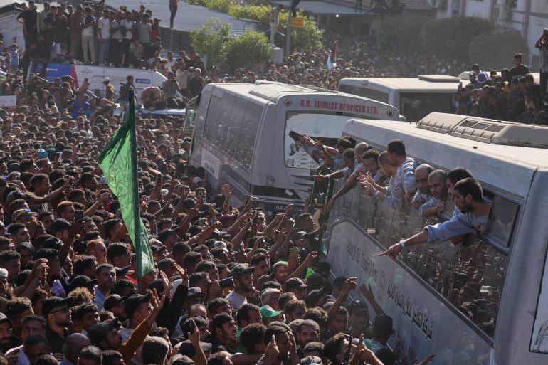 People gather to greet freed Palestinian prisoners arriving on buses in the Gaza Strip after their release from Israeli jails under a ceasefire agreement between Hamas and Israel, outside Nasser Hospital in Khan Younis, southern Gaza Strip, Monday, Oct. 13, 2025. (AP Photo/Jehad Alshrafi)