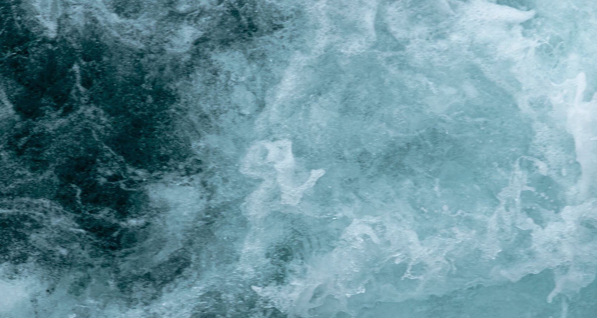 A swirl of blue and white shows ocean waves roiling in the water