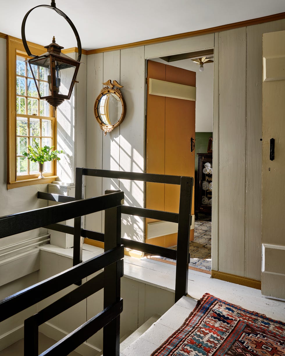 small stairwell from 1600s house painted in a creamy white color with ochre yellow trim