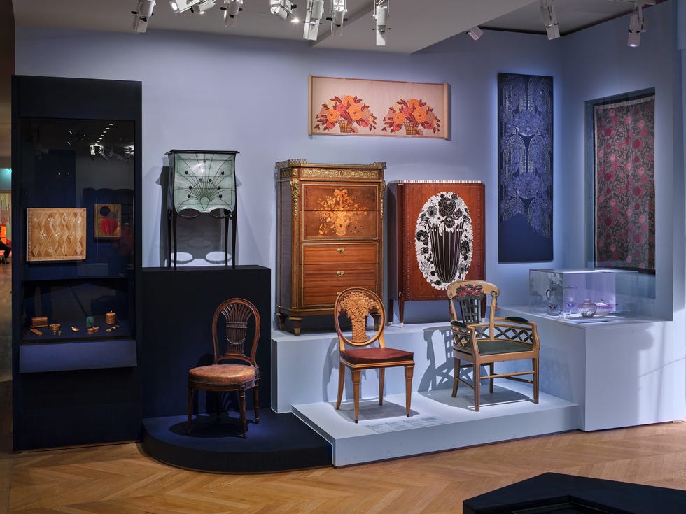 Display of vintage furniture and decorative items in a gallery.