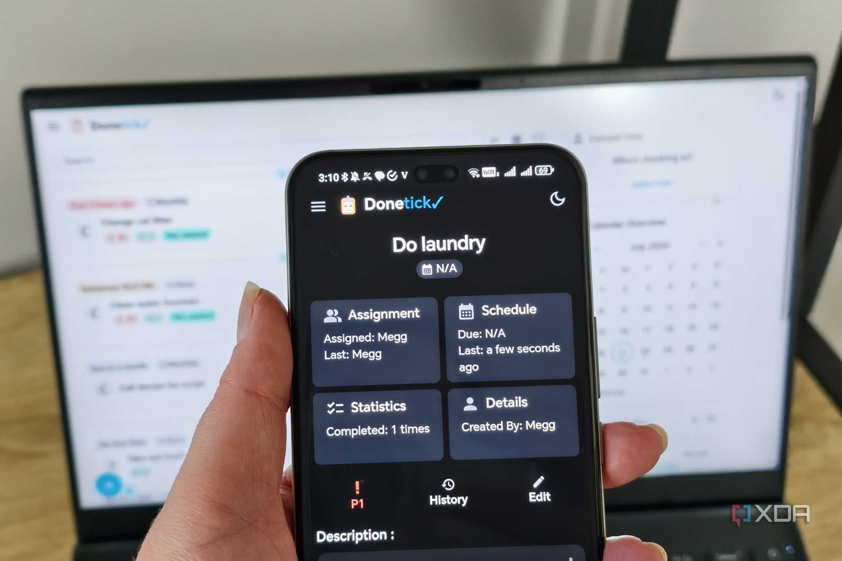 donetick site on a phone with laptop in background